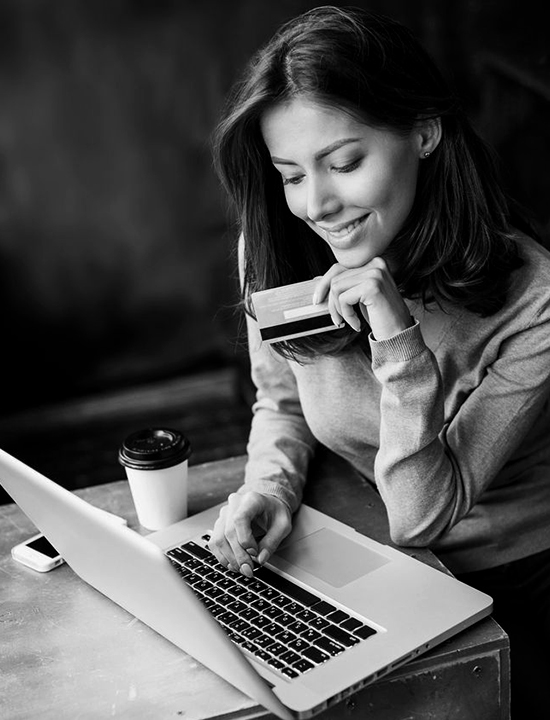 Women at coffee shop with laptop and credit card