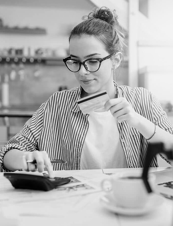 Girl with glasses with debit card and calculator