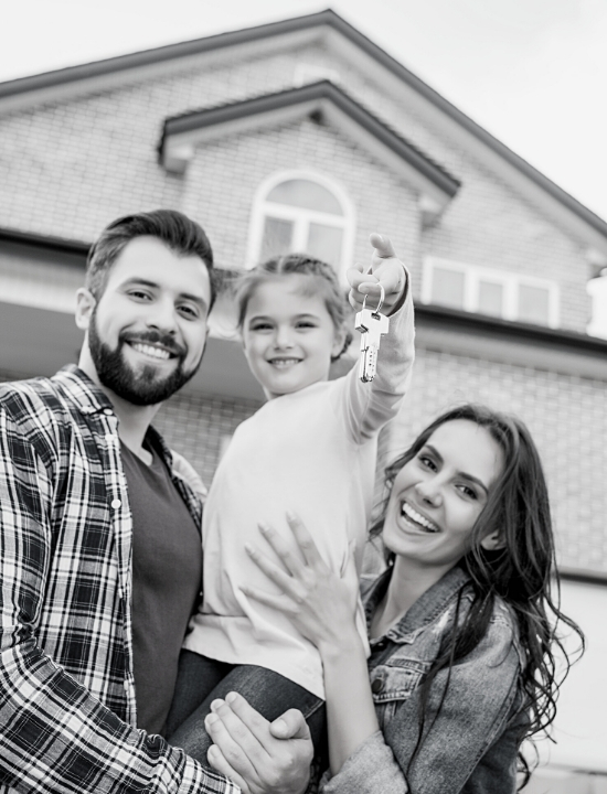 younger couple with daughter holding keys to new house