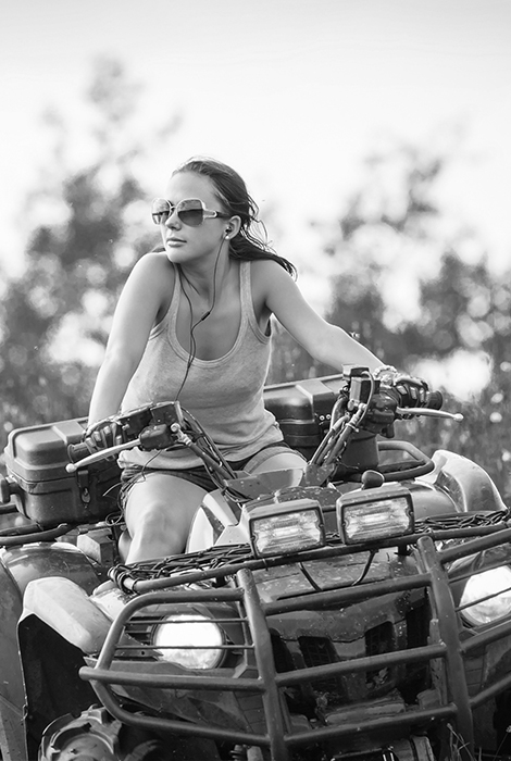 Women riding a four-wheeler with sunglasses on