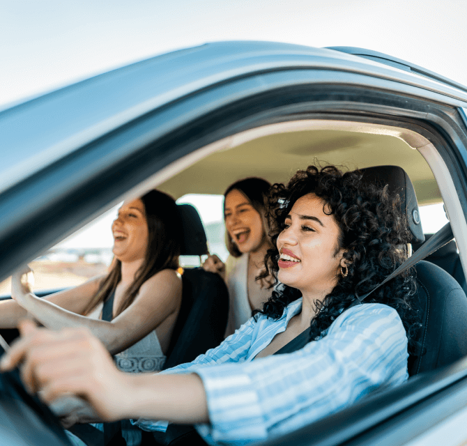three girls happy in a car