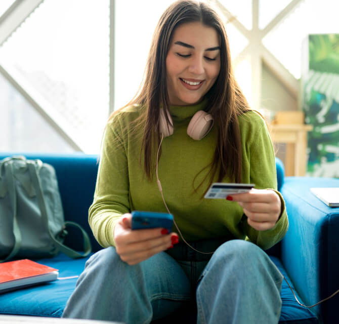 Girl with mobile phone and holding debit card